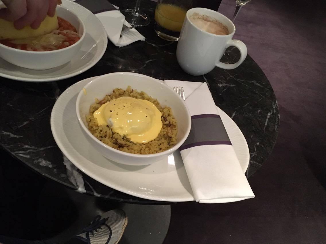 a bowl of kedgeree on a black marble table in the No1 Traveller Lounge Gatwick North terminal
