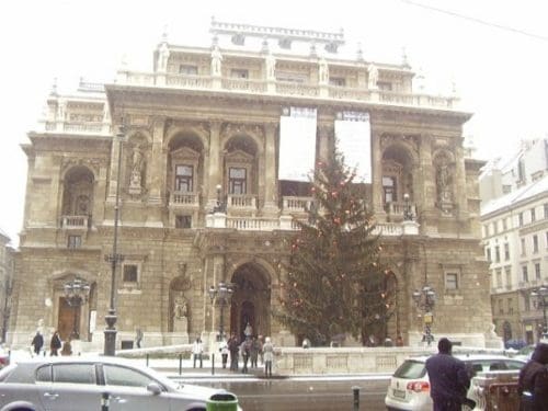 a large christmas tree and snow on the rooftops outside the Magyar Allami Operahaz, Hungarian State Opera House, Budapest