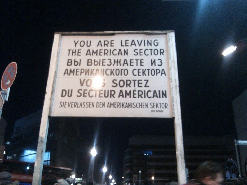 white wooden sign with black writing in English, Russian, French and German at Checkpoint Charlie, Berlin, Germany