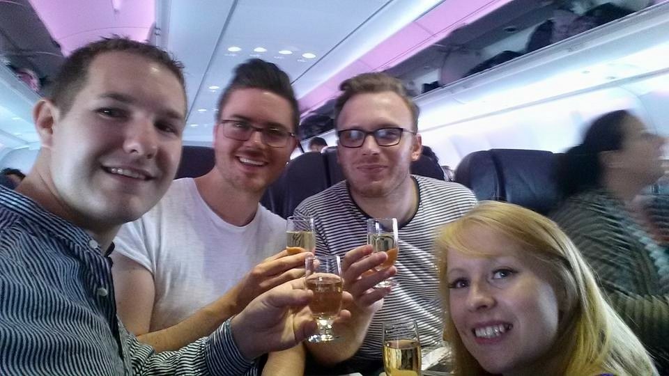 Karl, Rosie and two friends post for a selfie on a plane with champagne in Vrigin Atlantic Premium Economy seats