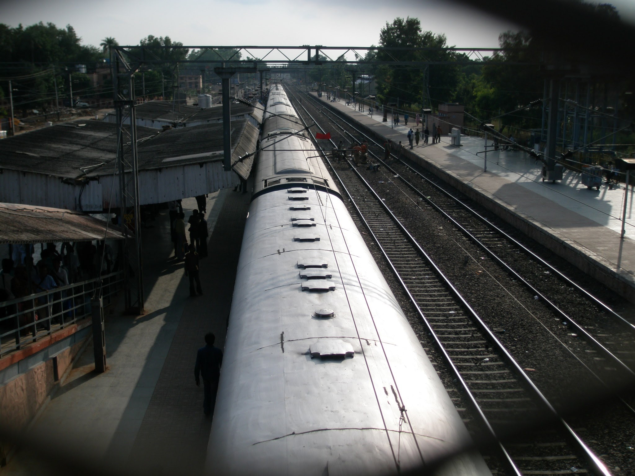 The top of train carriages sitting on a station platform in India