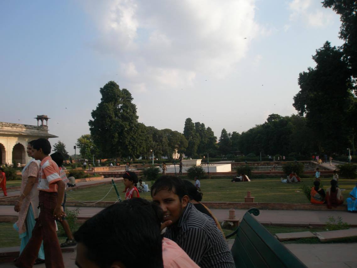 Indian tourists relaxing and walking in the gardens of Red Fort Delhi, India