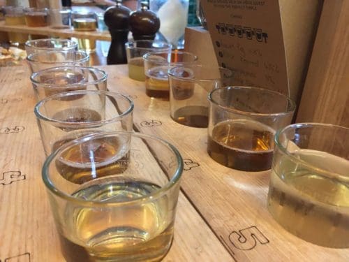5 half pint glasses of cider in a numbered, wooden board at The Stable