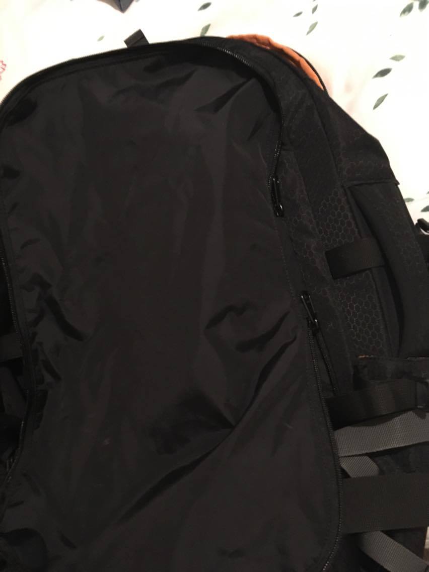 The strap cover on the back of a black Kathmandu Litehaul 38L Backpack
