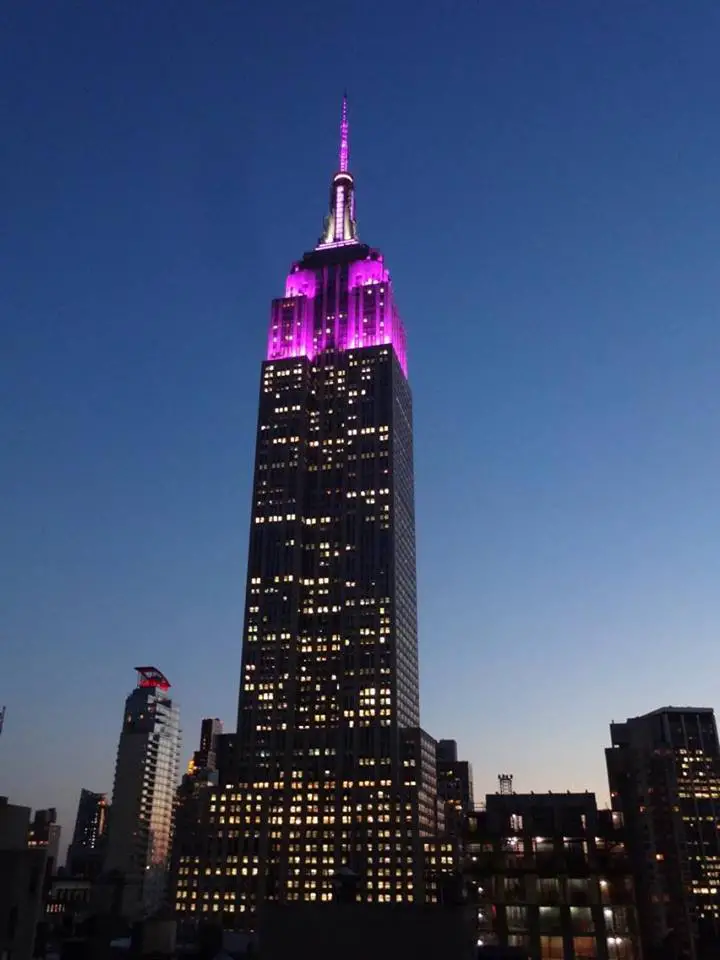 The Empire State Building, lit in purple in New York City at dusk