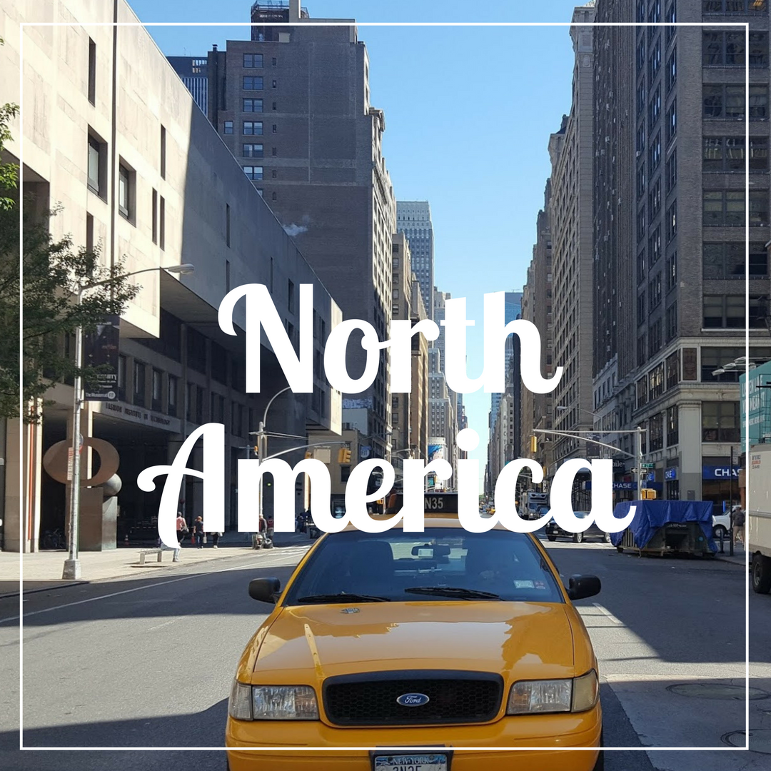 "North America" written over a photo of a yellow New York Taxi in the foreground on a street with tall buildings either side