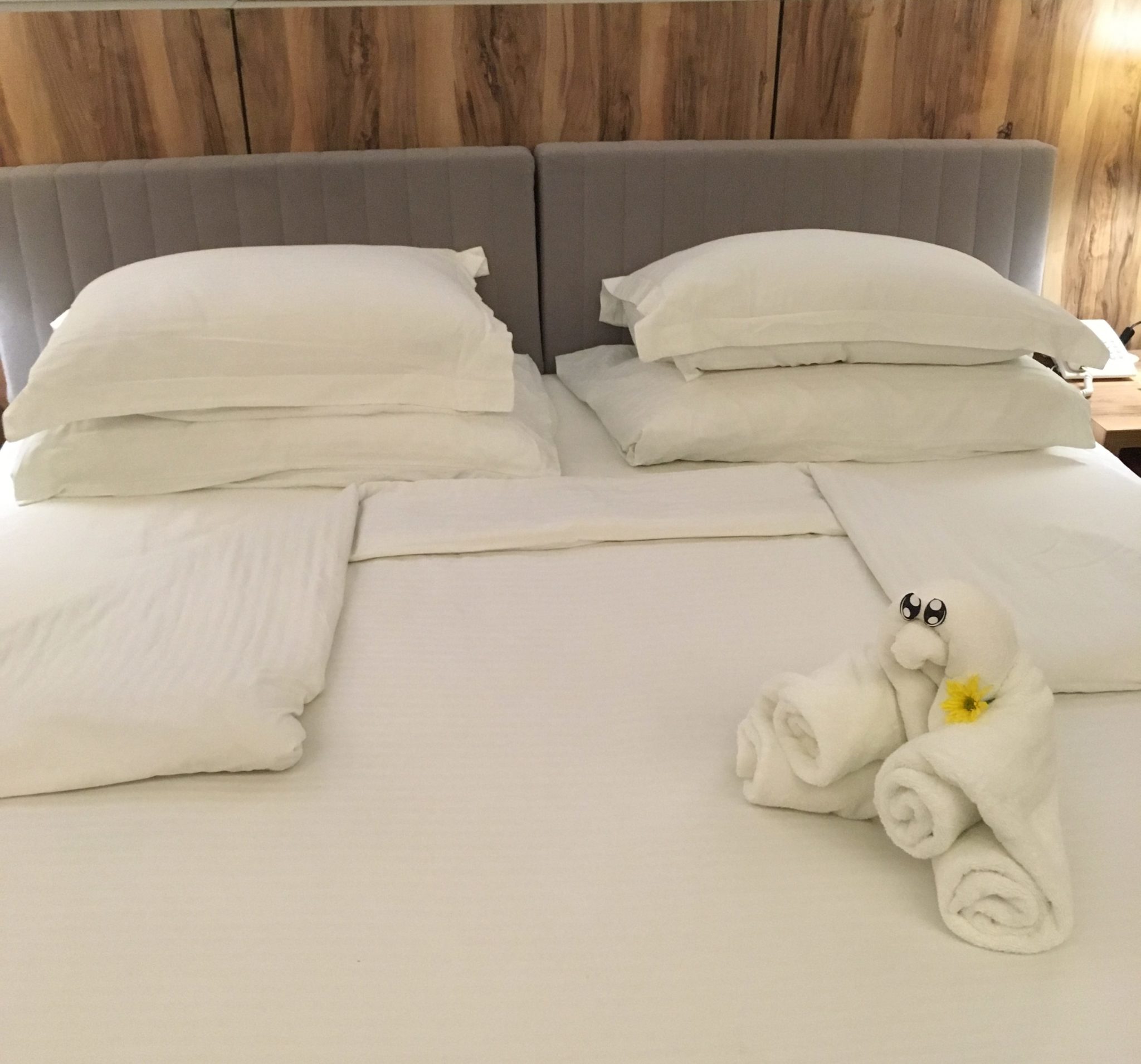 Towel art on a white king size bed