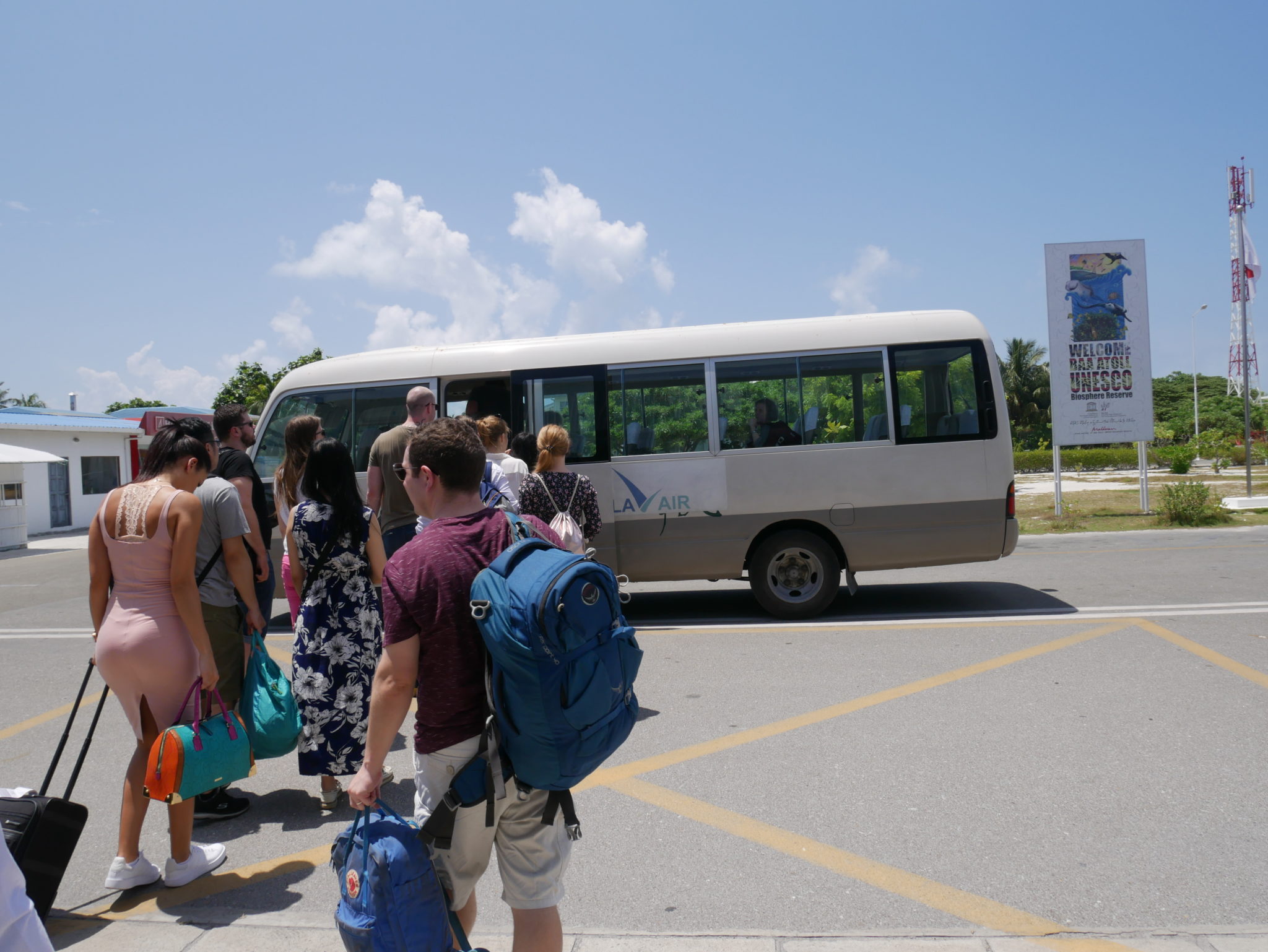 Tourists queue to board a minibus with their hand luggage in the Maldives