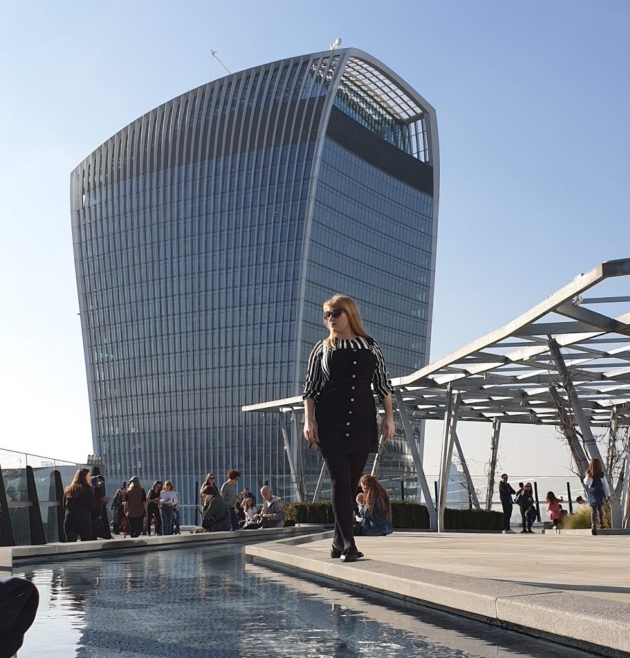 Rosie standing on the edge of a pool in front of 20 Fenchurch Street building