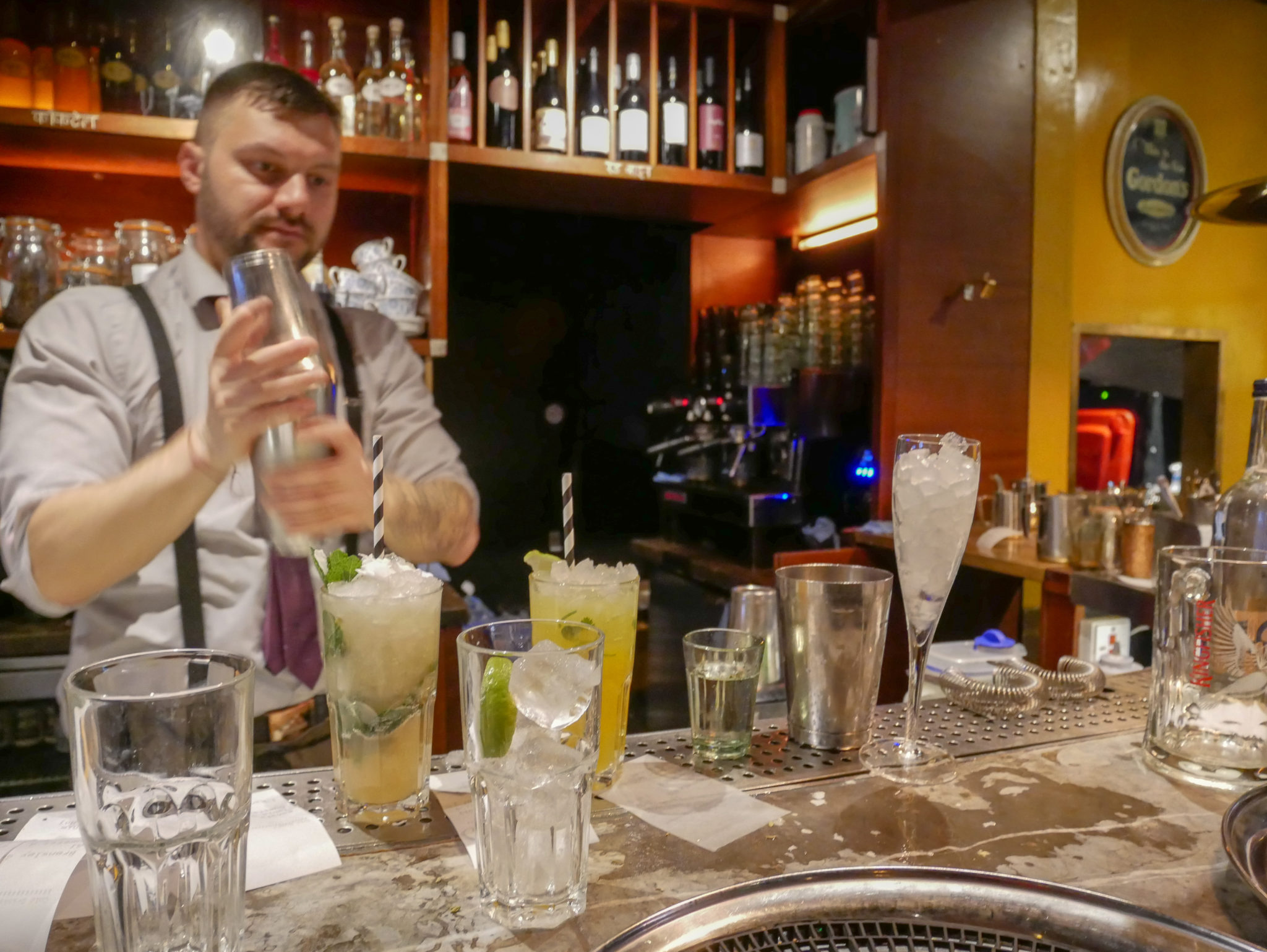 a barman shakes a cocktail shaker at the bar in Dishoom, Soho, London