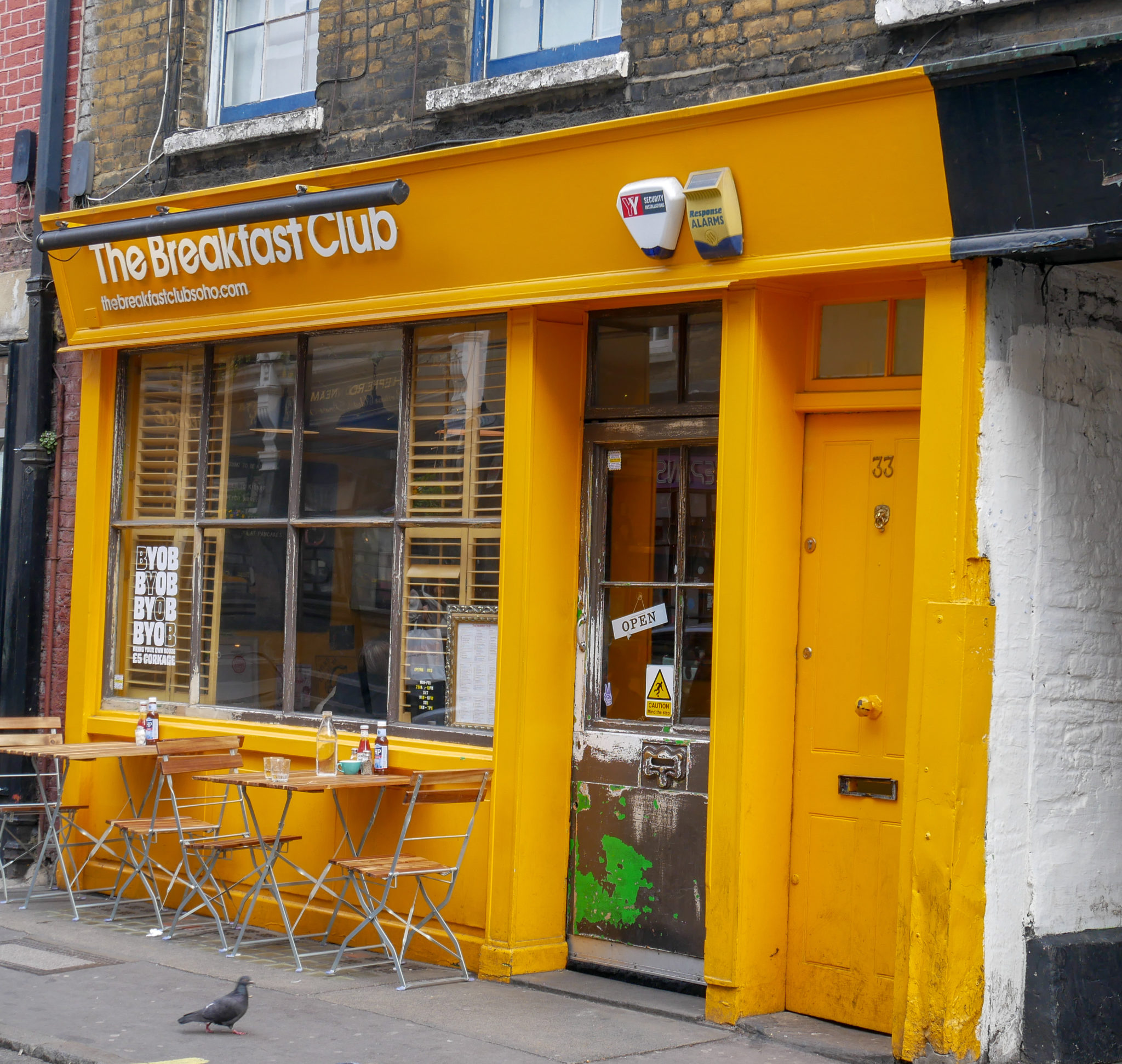 The yellow walls, door and sign of The Breakfast Club, Soho, London