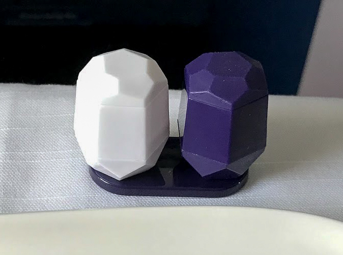 a white and blue plastic salt and pepper pots on Delta One Delta Air Lines