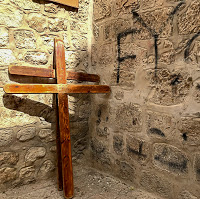2 wooden crosses leaning against a stone wall in Jerusalem