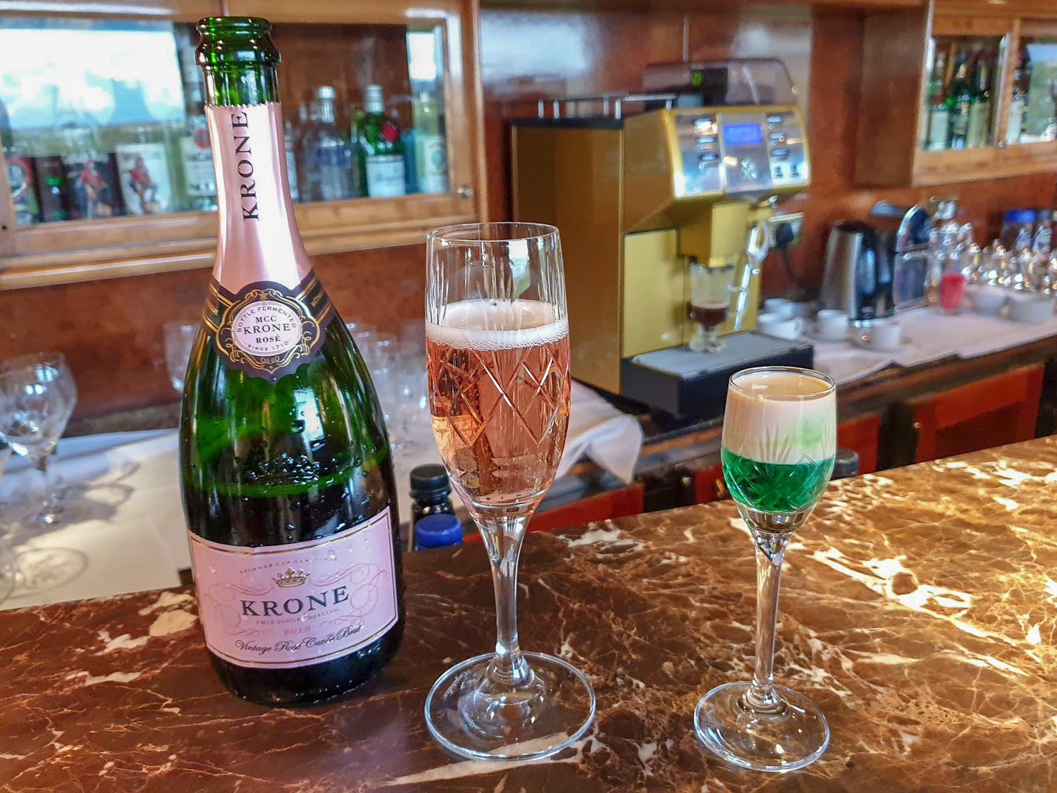 Krone Curvée Rosé Brut sparkling wine and a Springbok shot on the bar of the Lounge Car on The Blue Train