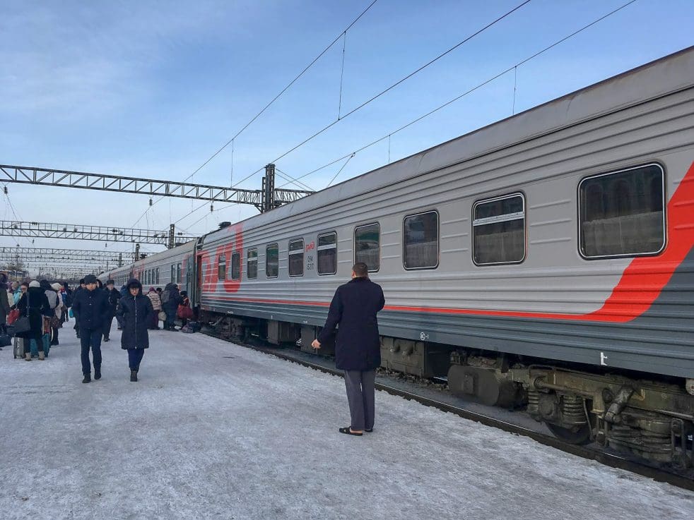 A Trans-Siberian train on a busy platform in Russia