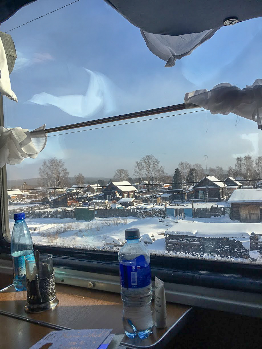 Houses covered in snow from the window of a Trans-Siberian Train