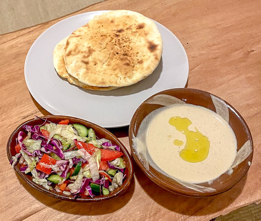 2 round flatbread, tahini dip and a pink, red and green salad at Aqua Sun, Gulf of Aqaba, Egypt