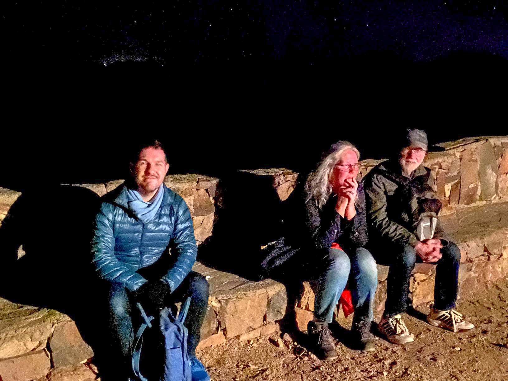 Karl and two walkers rest on a stone bench at night, Mount Sinai, Egypt