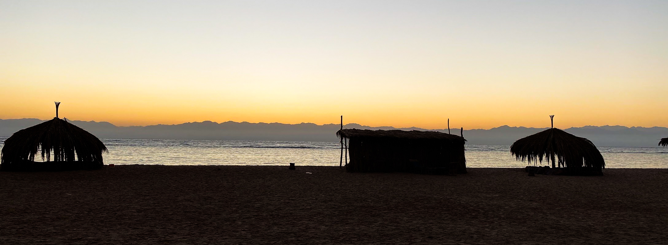 silhouette view of the bech huts against the sunrise sky at Aqua Sun Beach Camp, Sinai, Egypt