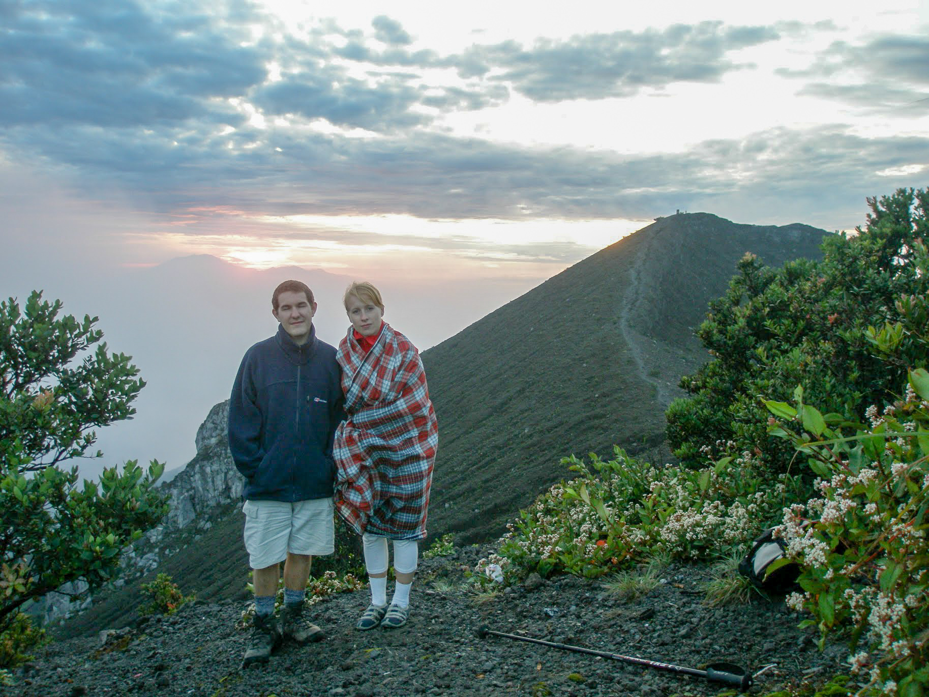 Karl and Rosie (wrapped in a blanket) standing near the summit of Mount Merbabu, Indonesia