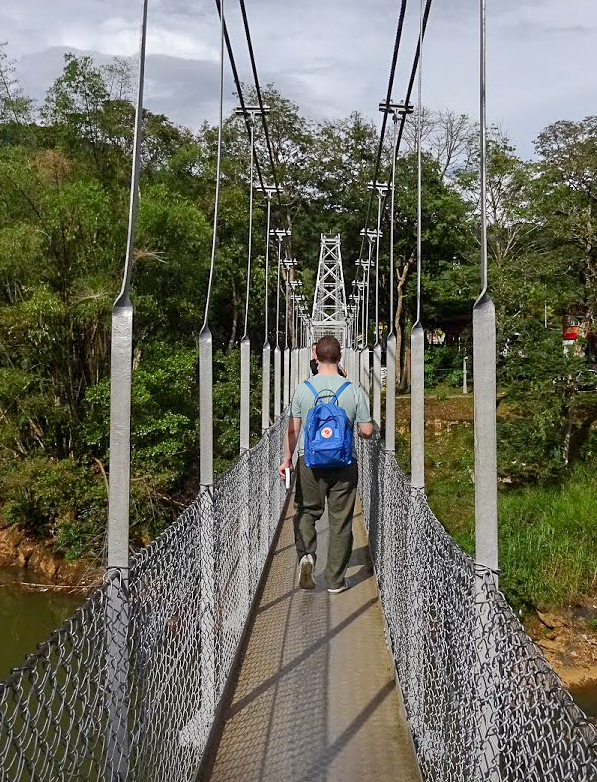 Karl walking across a metal bridge in the Royal Botanical Gardens, Peradeniya, Sri Lanka