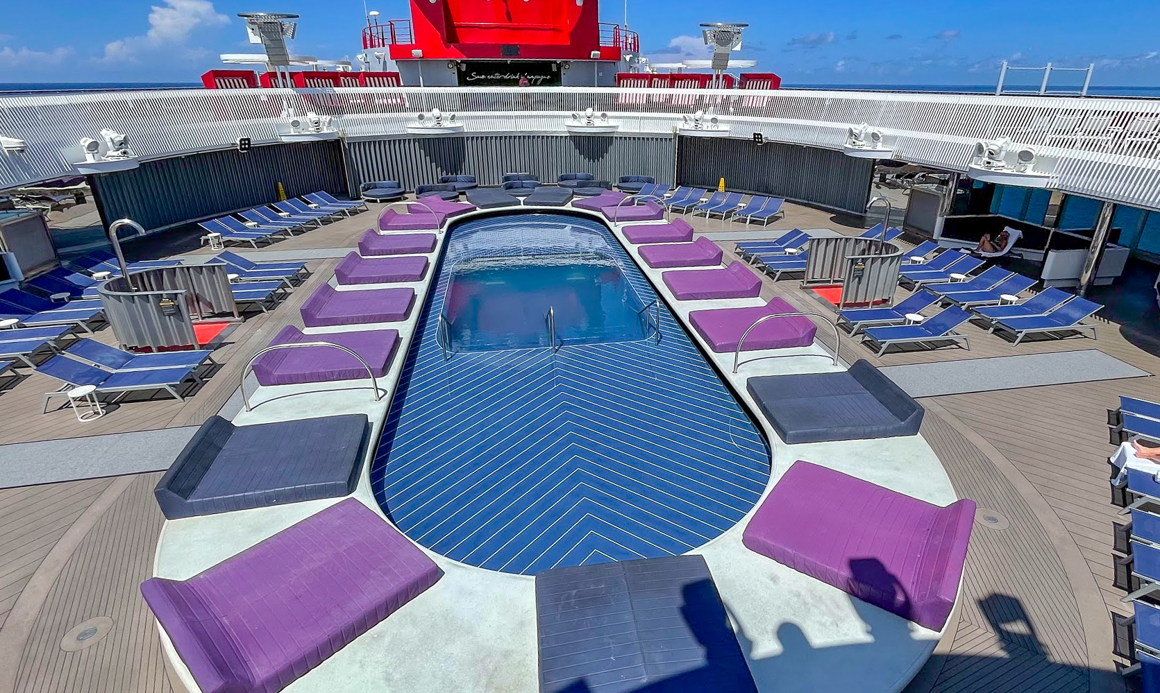 Virgin Voyages Pool surrounded by blue sun loungers